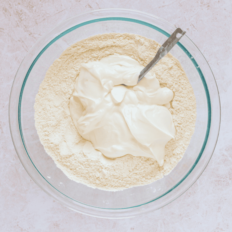 Folding yogurt into dry ingredients to form soft croissant dough.