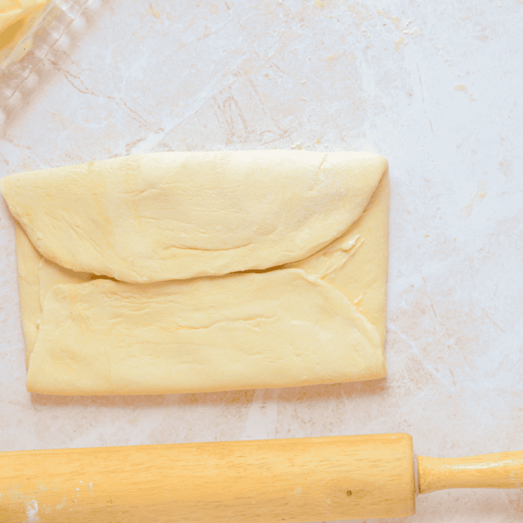 Cutting rolled dough into triangles and shaping into croissants.