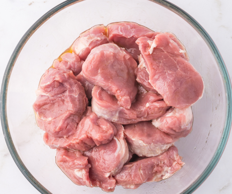 "Placing seasoned pork medallions in the air fryer basket for cooking."