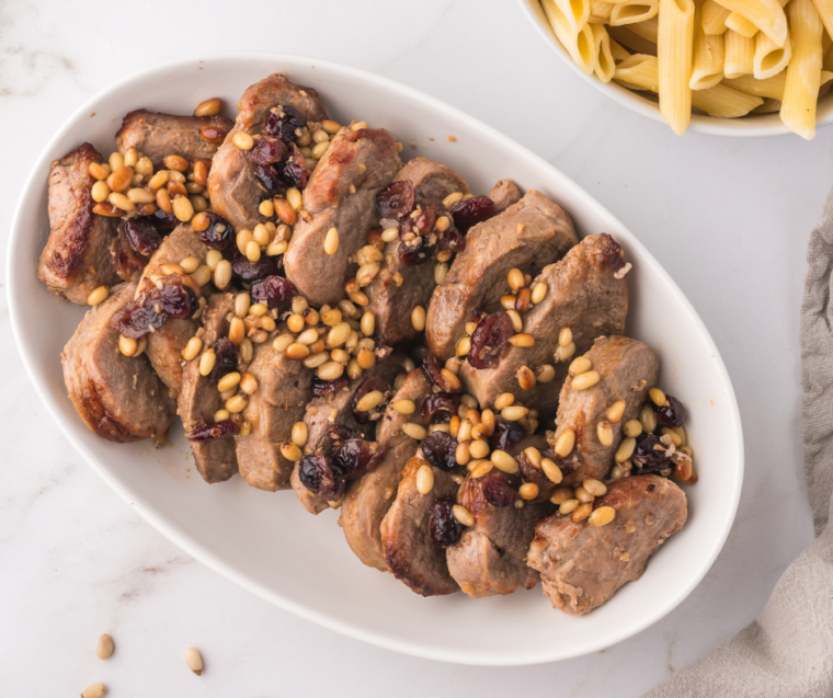 Delicious Air Fryer Pork Tenderloin Medallions served with a side of vegetables and drizzled with sauce."