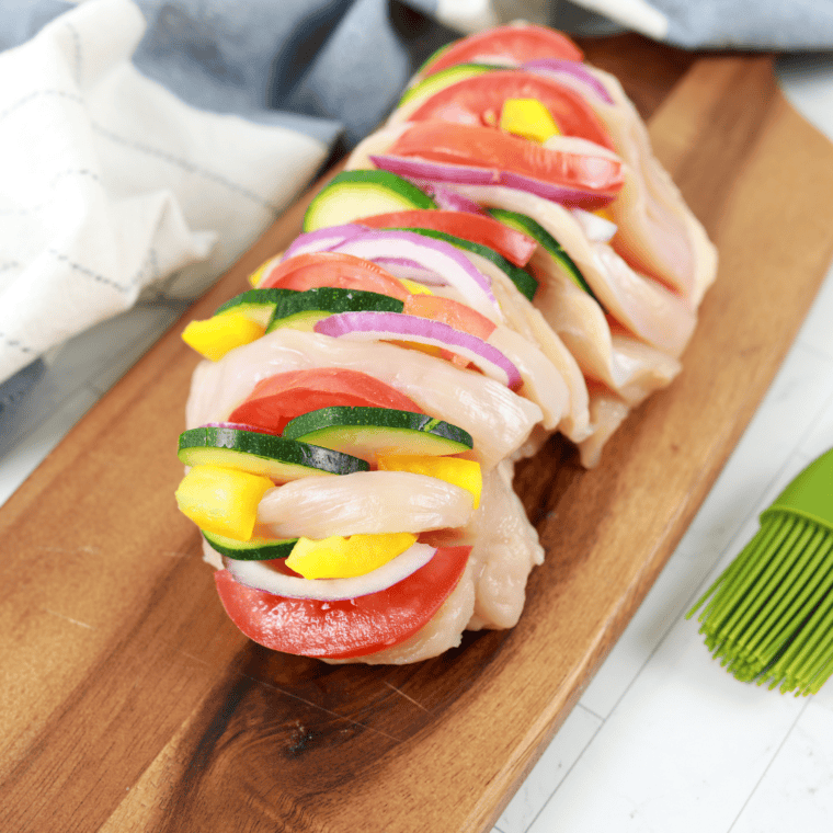 Stuffing the chicken breasts with the primavera filling – Primavera filling being placed inside the chicken breast pockets.