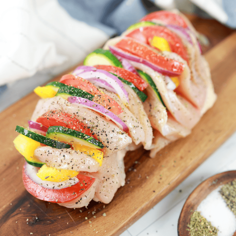 Brushing chicken with olive oil – Chicken breasts being lightly brushed with olive oil before cooking.