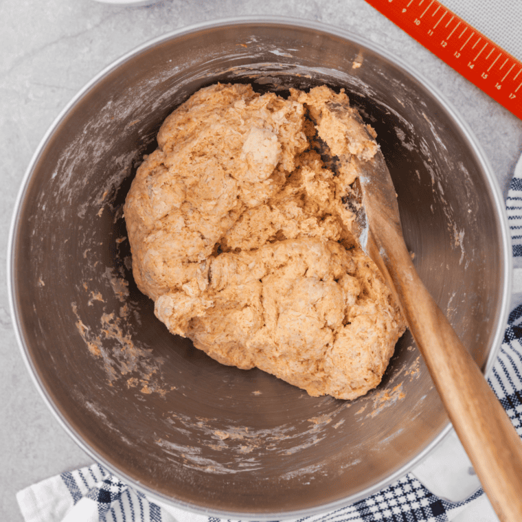 Mixing the pumpkin bagel dough in a bowl, combining ingredients for a smooth consistency
