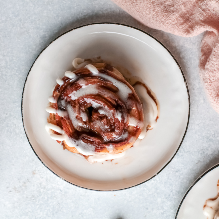 Air Fryer Pumpkin Cinnamon Rolls baked golden brown with sweet glaze drizzle on top.
