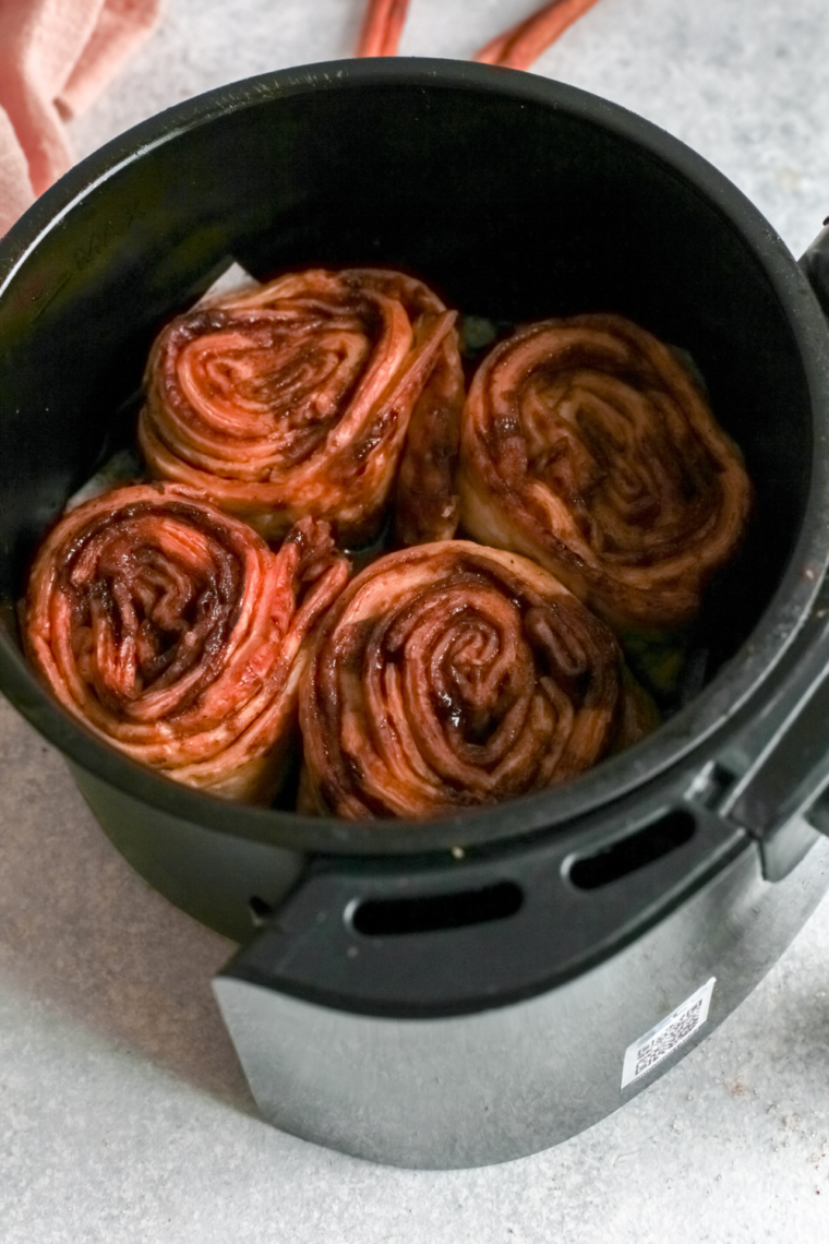 Cooked Pumpkin Cinnamon Rolls in the air fryer basket.