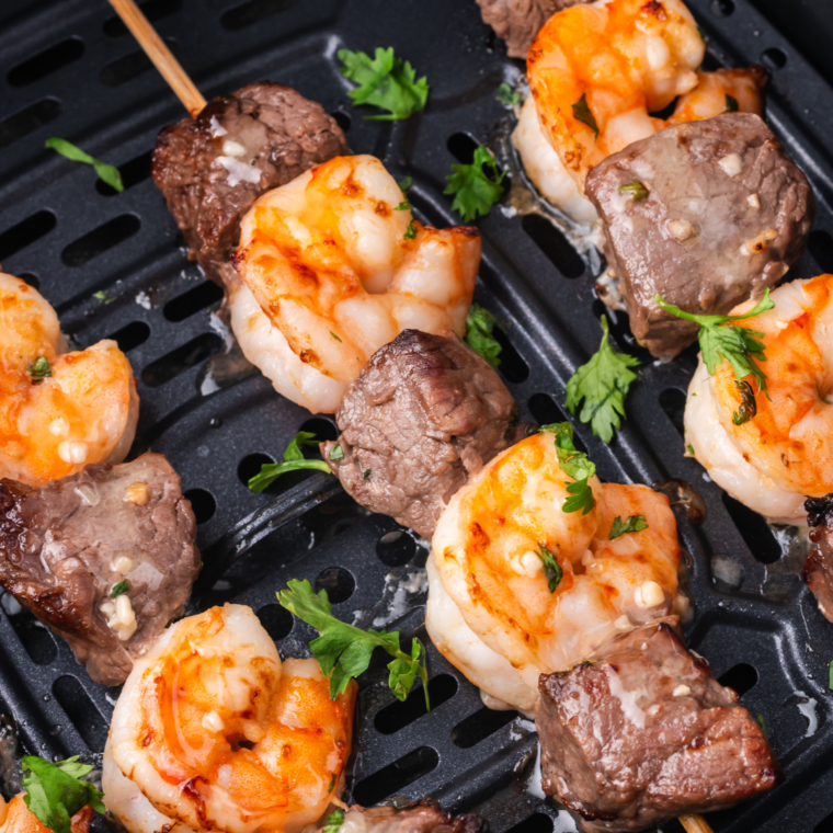 "Delicious Air Fryer Surf and Turf with perfectly cooked shrimp and steak kebabs, served with a fresh garnish."
