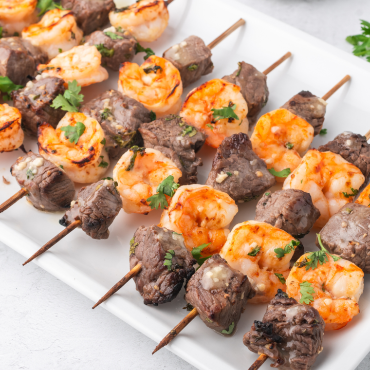 "Air Fryer Surf and Turf with steak and shrimp skewers, cooked to perfection and garnished with fresh herbs."