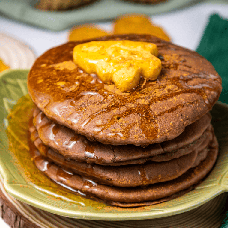 Stack of fluffy brown sugar pancakes topped with butter and syrup