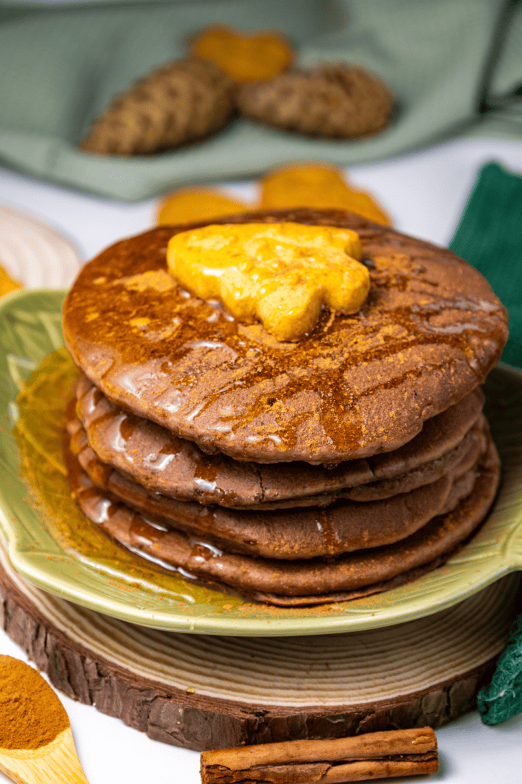 Close-up of golden brown sugar pancakes stacked on plate with syrup