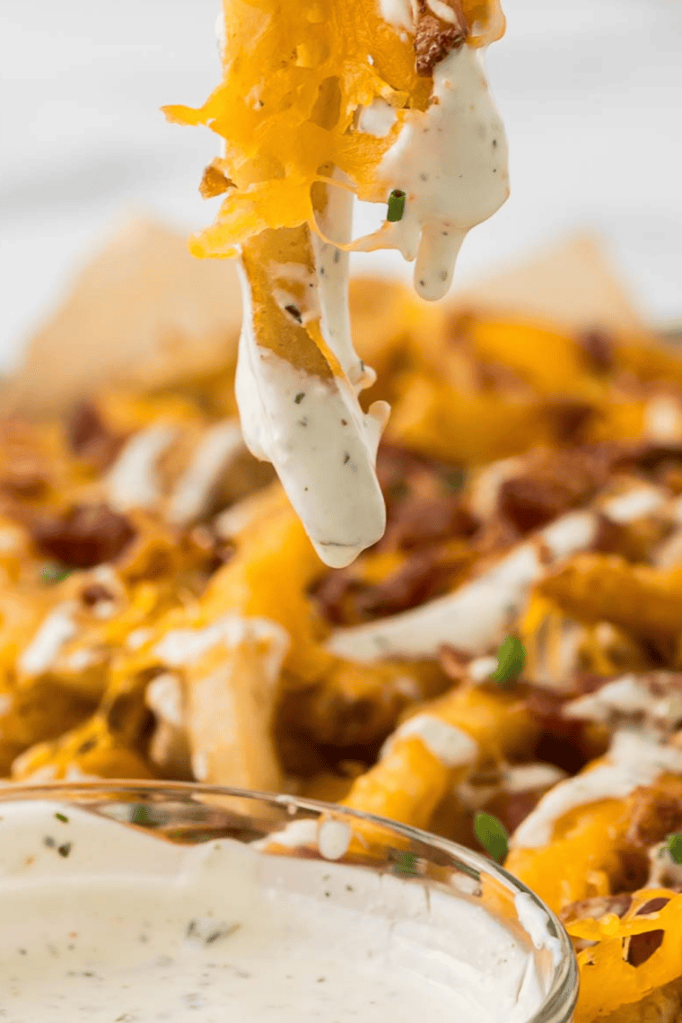 Homemade copycat Wingstop ranch dressing in a bowl with wings and vegetables for dipping.
