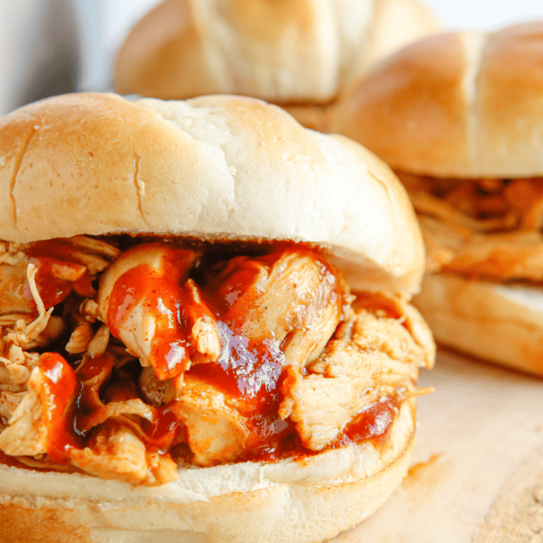Instant Pot BBQ shredded chicken piled on a toasted brioche bun with coleslaw