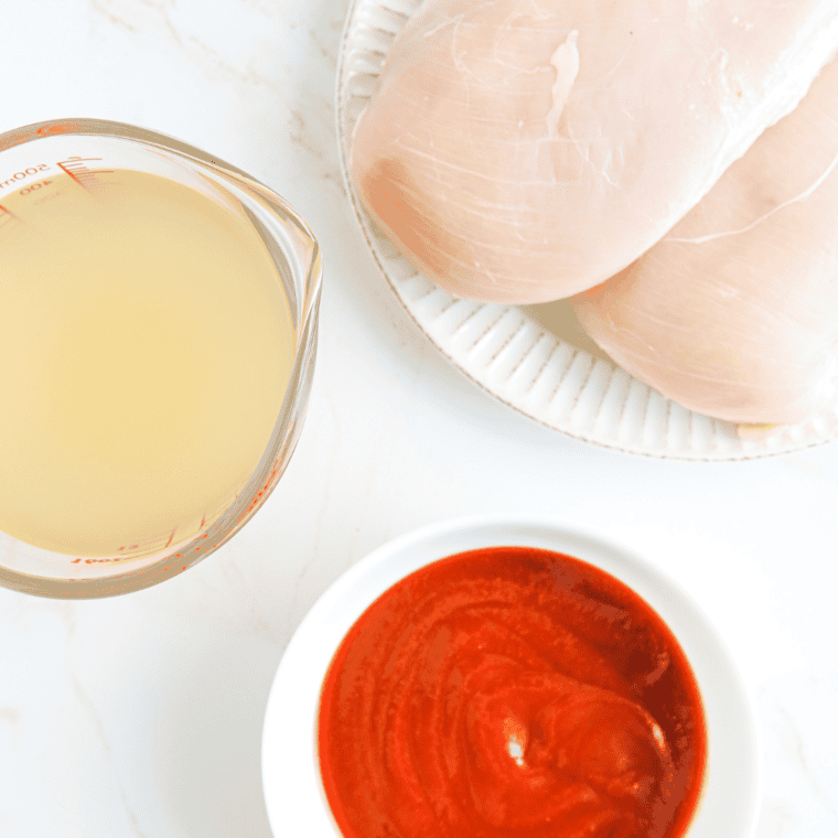 Ingredients for Instant Pot BBQ shredded chicken: raw chicken breasts, BBQ sauce, chicken broth, honey, Worcestershire sauce, and seasonings
