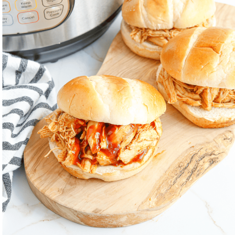 Bowl of Instant Pot BBQ pulled chicken garnished with chopped parsley.