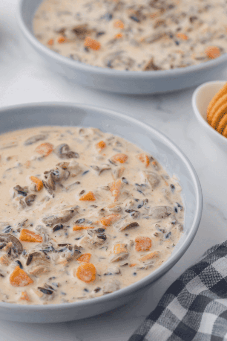 owl of Instant Pot Panera Bread copycat chicken wild rice soup, creamy with chicken, wild rice, and vegetables, garnished with parsley.