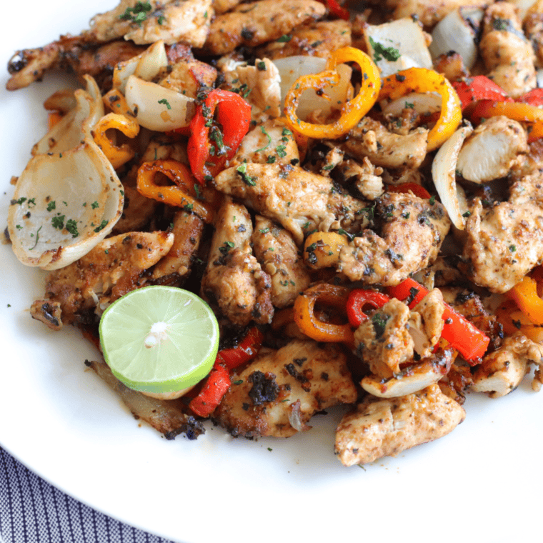 Cooked Ninja Foodi chicken fajitas with charred bell peppers and onions in the basket