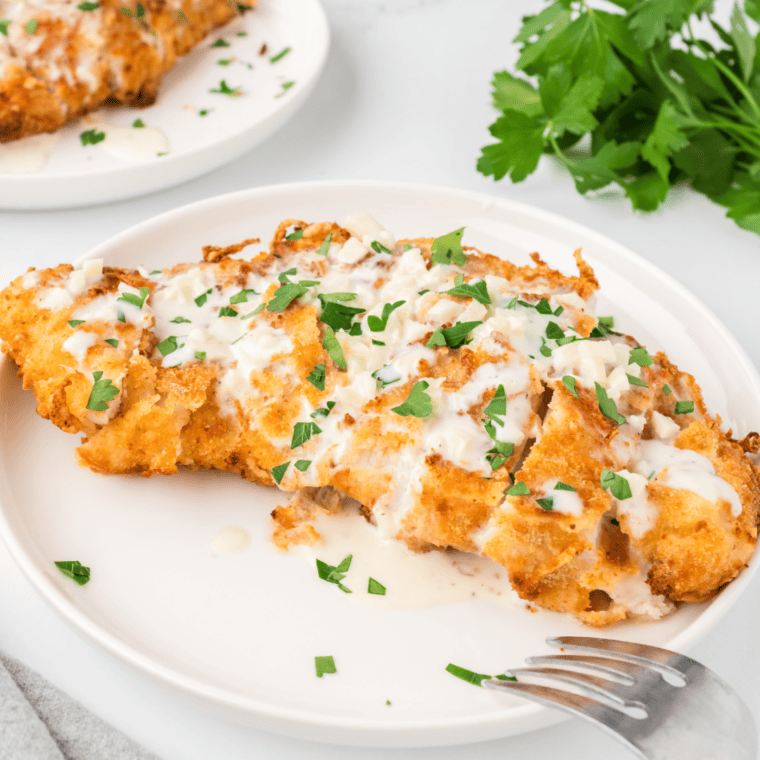 Serving finished Olive Garden Chicken Scampi with creamy garlic sauce and vegetables.