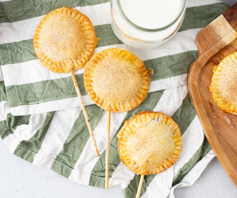 Air fryer apple pie pops with golden flaky pastry and cinnamon-spiced apple filling on sticks