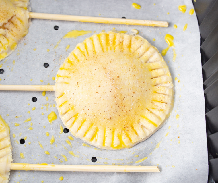 Apple pie pops cooking in the air fryer until golden brown and crispy
