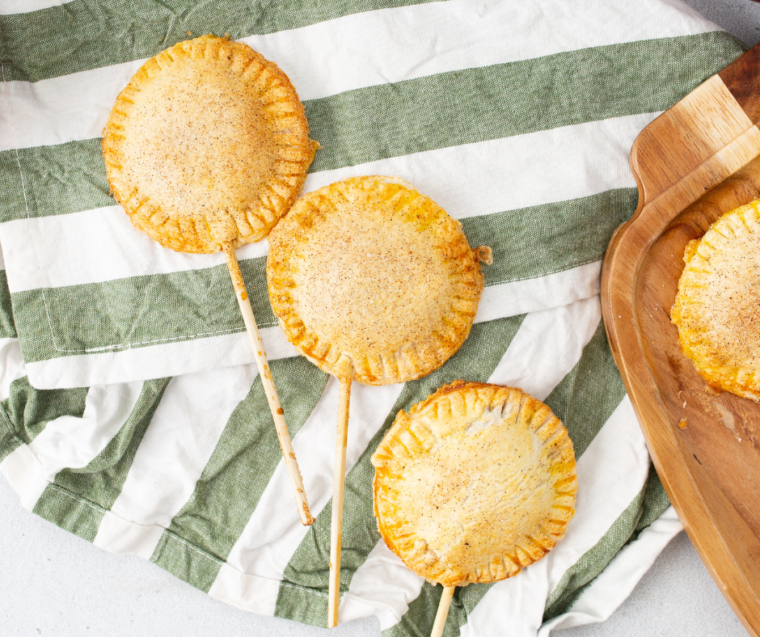 Air fryer apple pie pops with golden flaky pastry and cinnamon-spiced apple filling on sticks