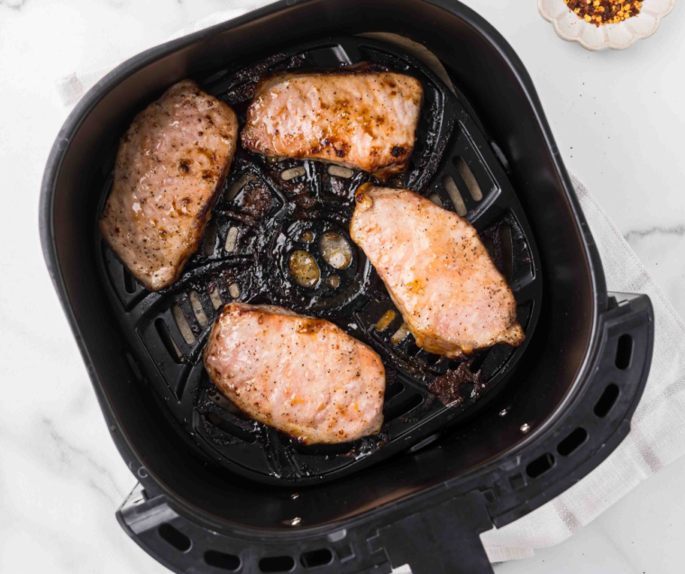 Golden brown apricot pork chops cooked through in the air fryer basket