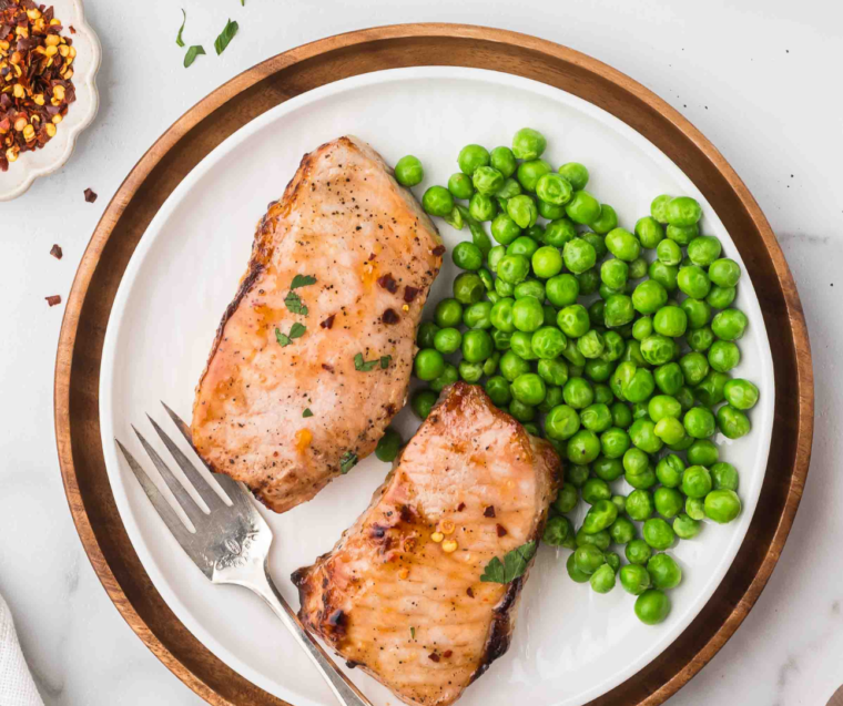 Air fryer apricot pork chops served with sides for an easy weeknight dinner