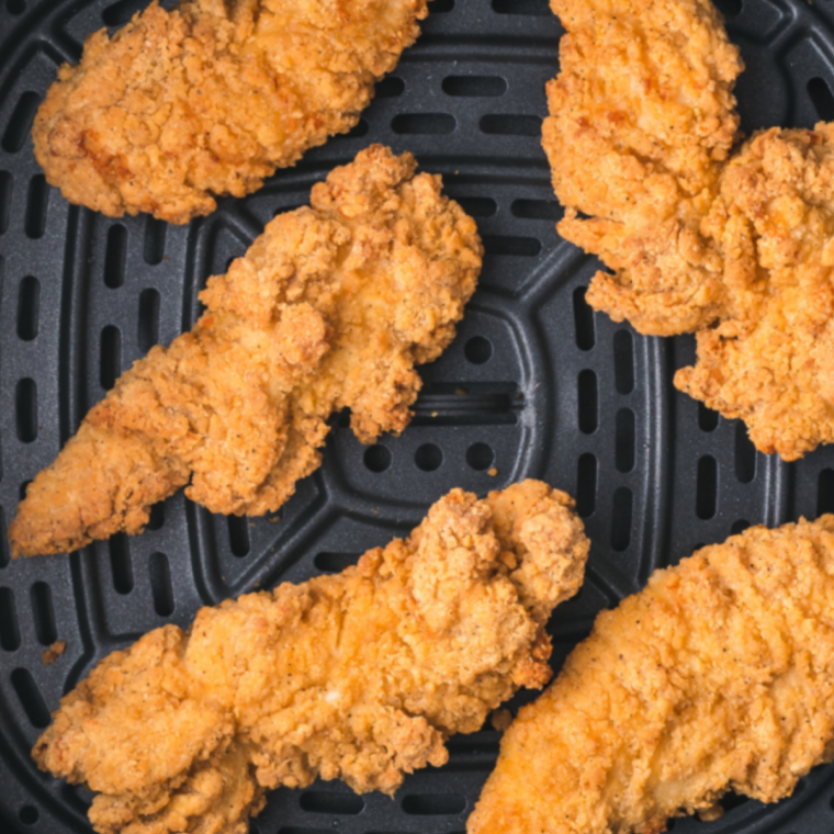 Breaded chicken cooking in an air fryer set to 375°F until golden brown