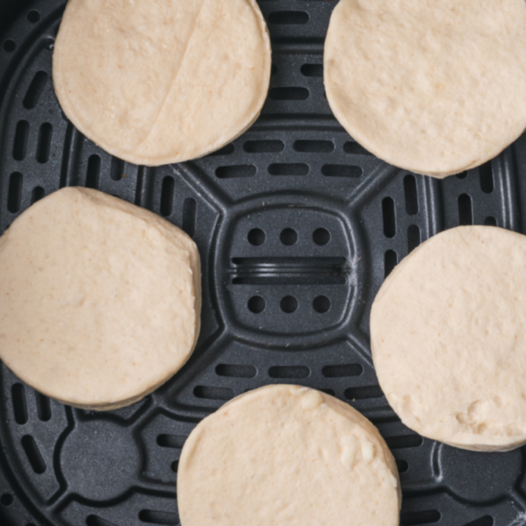 Buttermilk biscuits air frying until golden and flaky in the air fryer basket