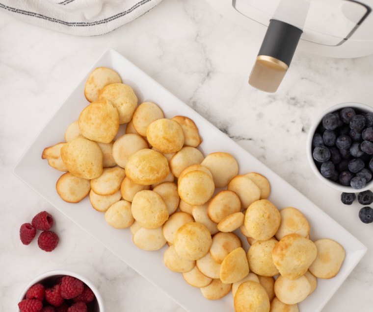 A bowl of crispy Air Fryer pancake cereal served with syrup and fresh berries.