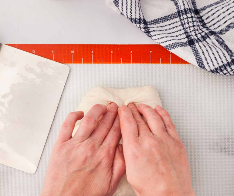 Kneading sourdough bread dough by hand on a lightly floured surface