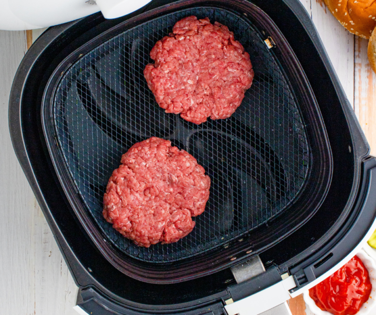 Ground beef patties seasoned with salt and pepper, shaped with a dimple in the center.