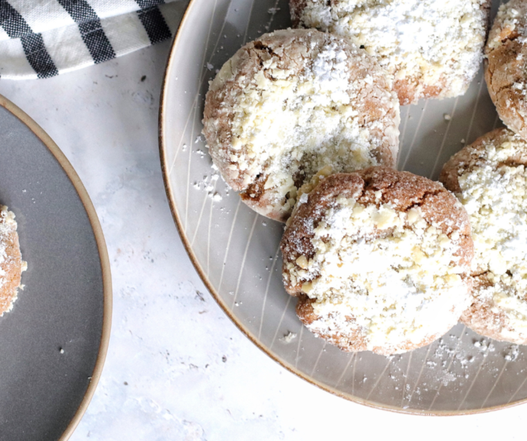 A stack of soft, spiced gingerbread crinkle cookies coated in cracked powdered sugar, showing a chewy interior and perfectly golden edges from the air fryer.