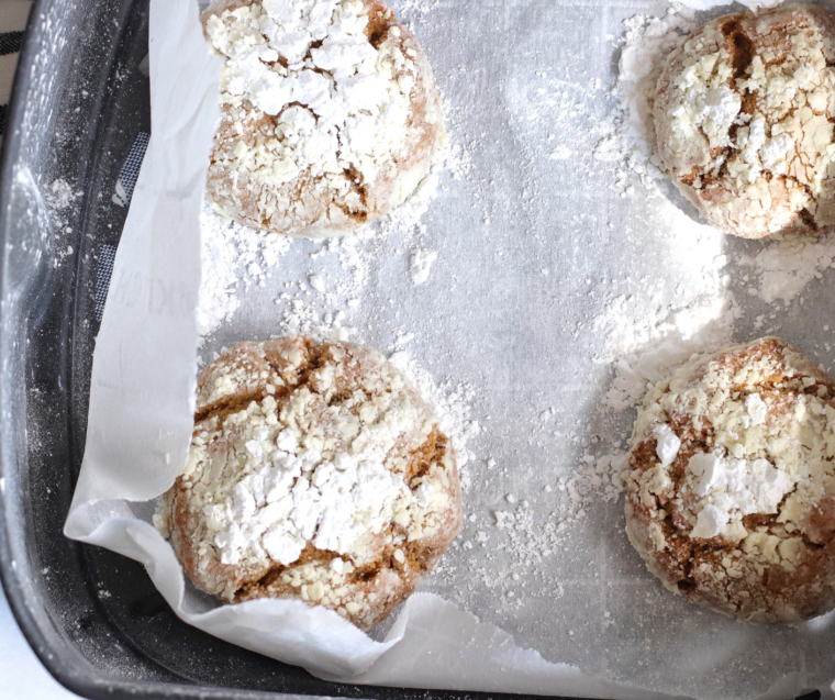Soft, spiced Air Fryer Gingerbread Crinkle Cookies with powdered sugar cracks on top, arranged on a plate.