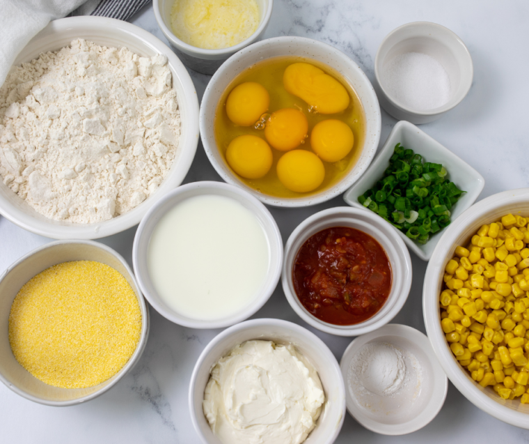 Ingredients for Blackstone street corn fritters including corn, cotija, cilantro, lime and cornmeal