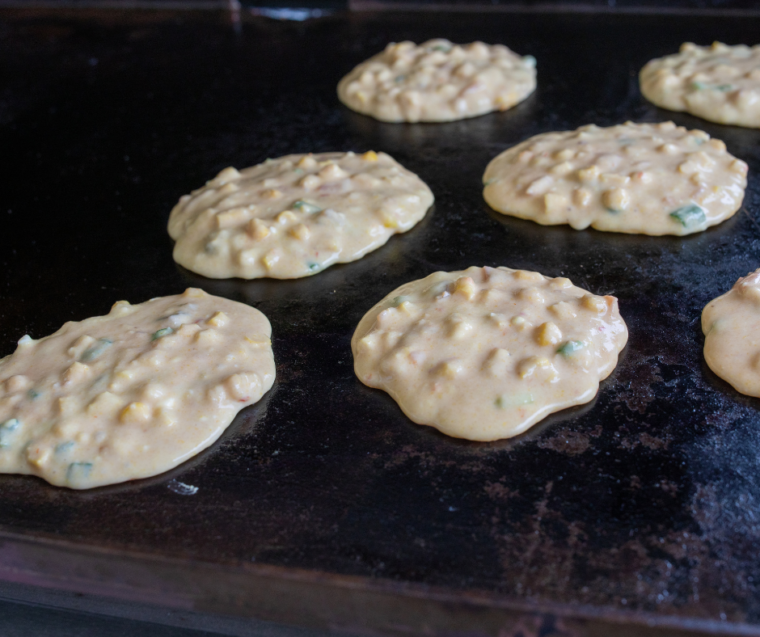 Charring corn kernels on a Blackstone griddle for street corn fritters