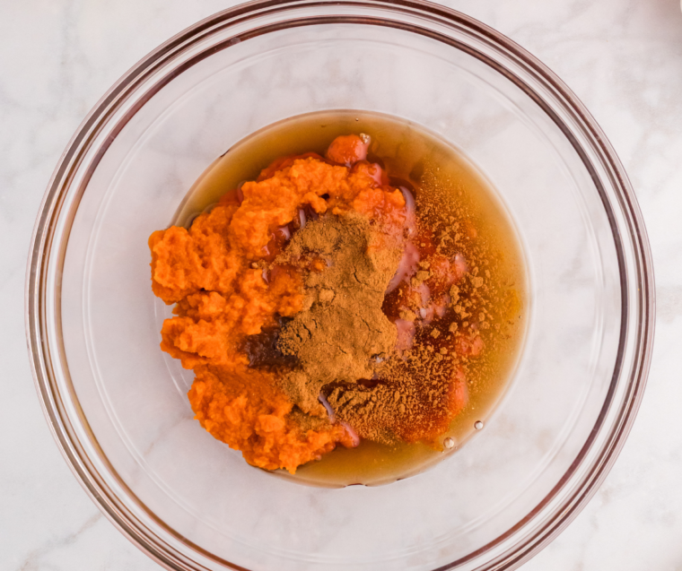 Whisking the keto pumpkin ice cream base in a glass mixing bowl