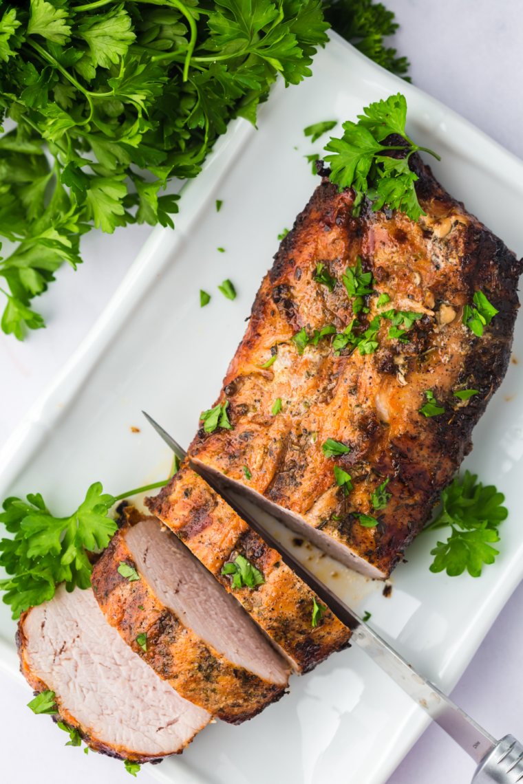 Juicy, char-grilled pork tenderloin cooked in a Ninja Foodi Grill, sliced and served