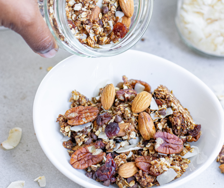 Crunchy air fryer muesli served in a white bowl with milk and fresh berries