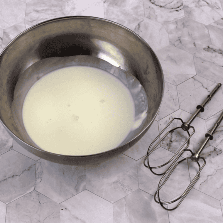 Whisking sugar, flour, and milk in a saucepan over medium heat until thick and bubbling