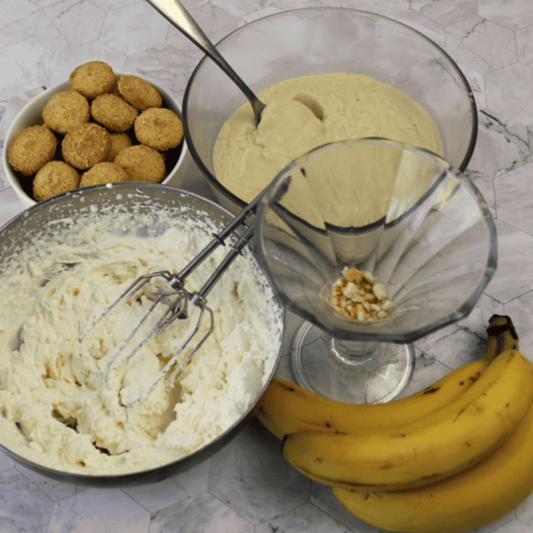 Layering vanilla wafers, banana slices, and pudding in a dish, then topping with whipped cream