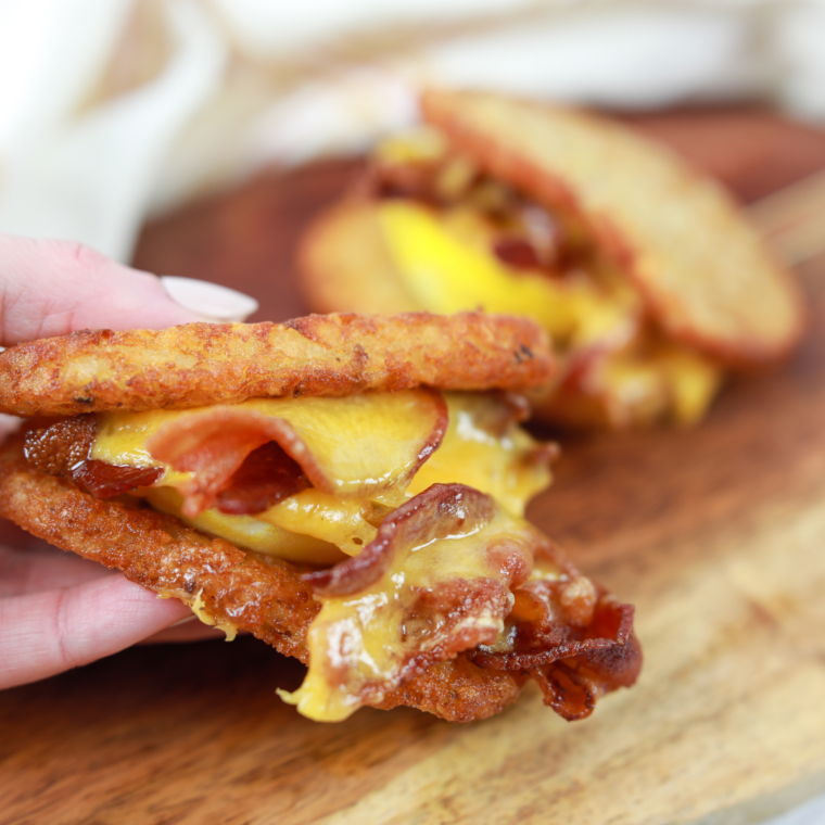 Golden, crispy Air Fryer Hash Brown Breakfast Sandwich stacked with egg, cheese, and sausage, served warm on a plate.