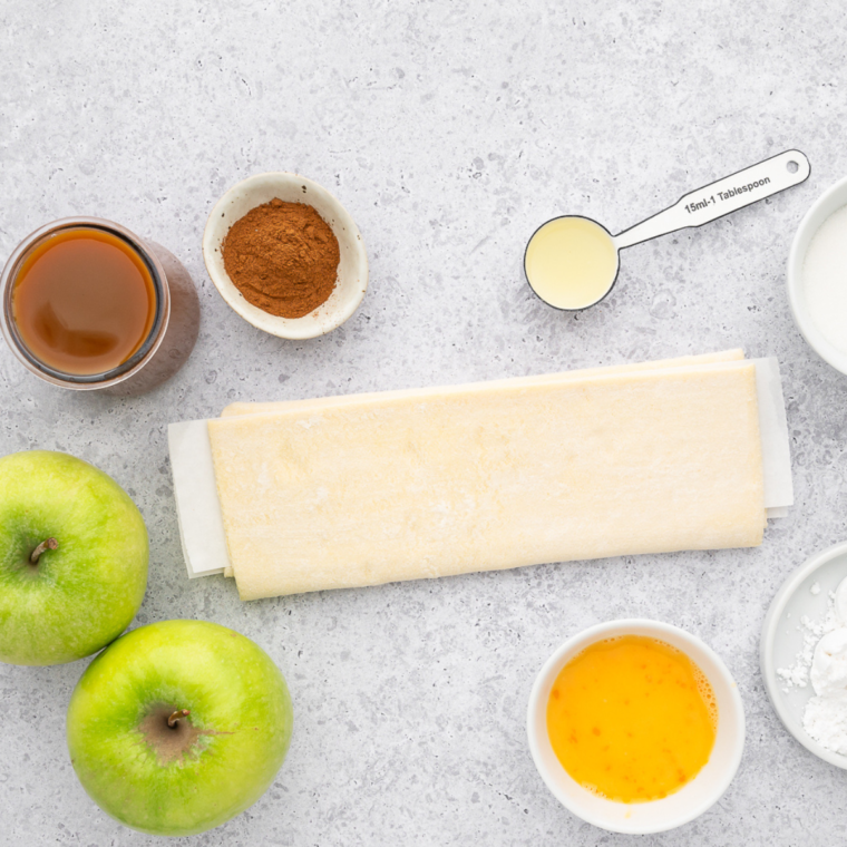 Air Fryer Puff Pastry Apple Rings ingredients arranged on a white table.