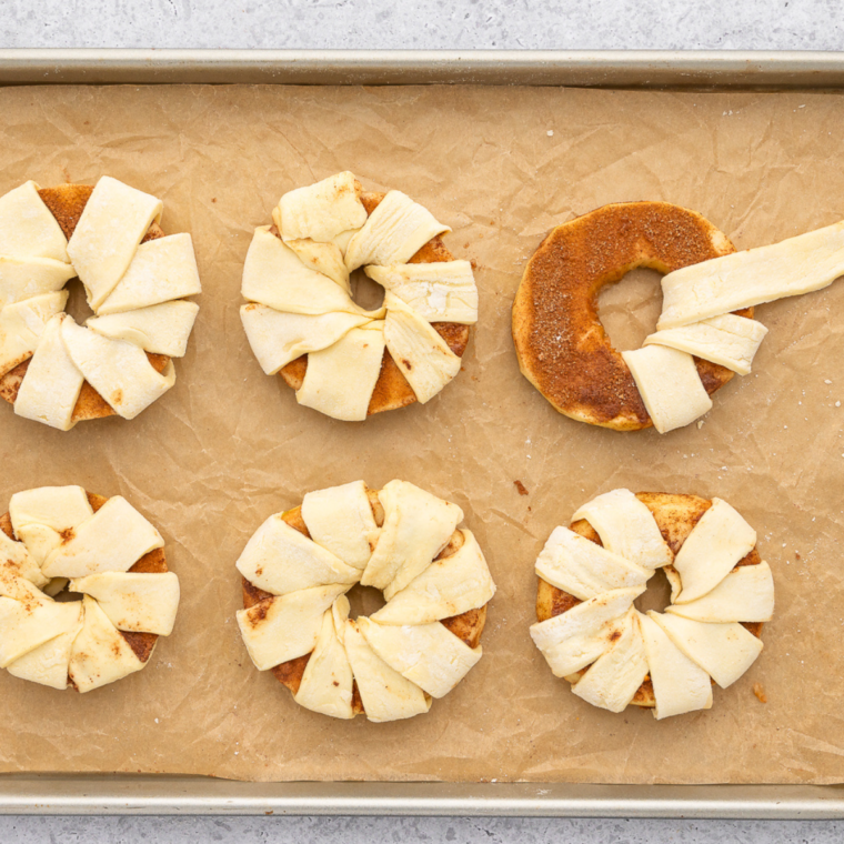 Apple slices wrapped with strips of puff pastry, showcasing the looping technique in the center.