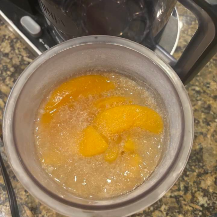 "Ninja Creami processing the frozen peach mixture into sorbet."