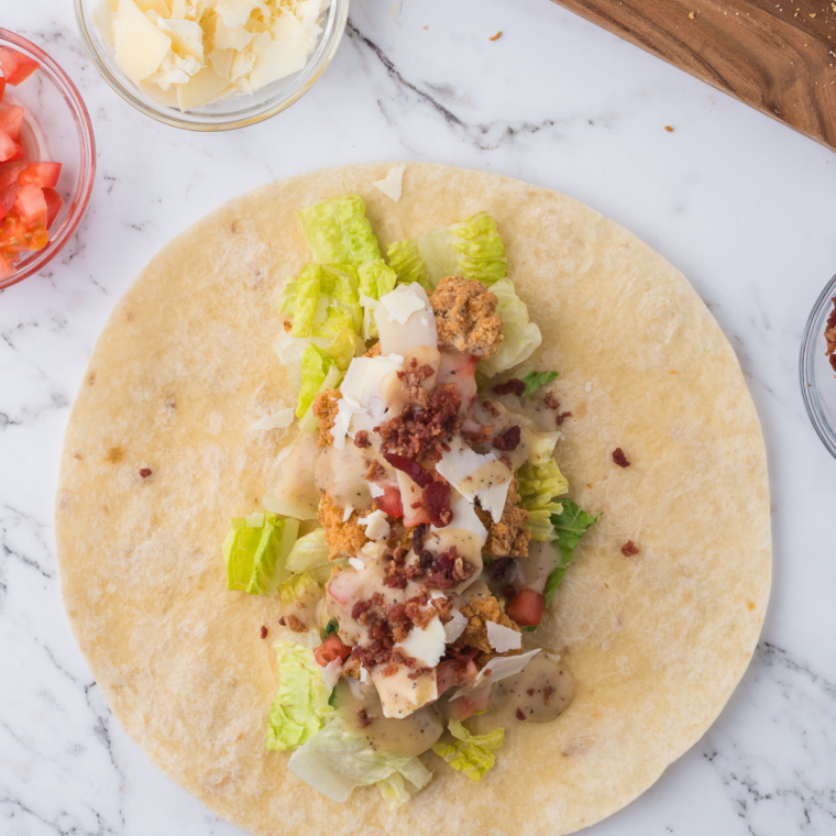 Flour tortilla filled with crispy chicken, Caesar dressing, and romaine lettuce