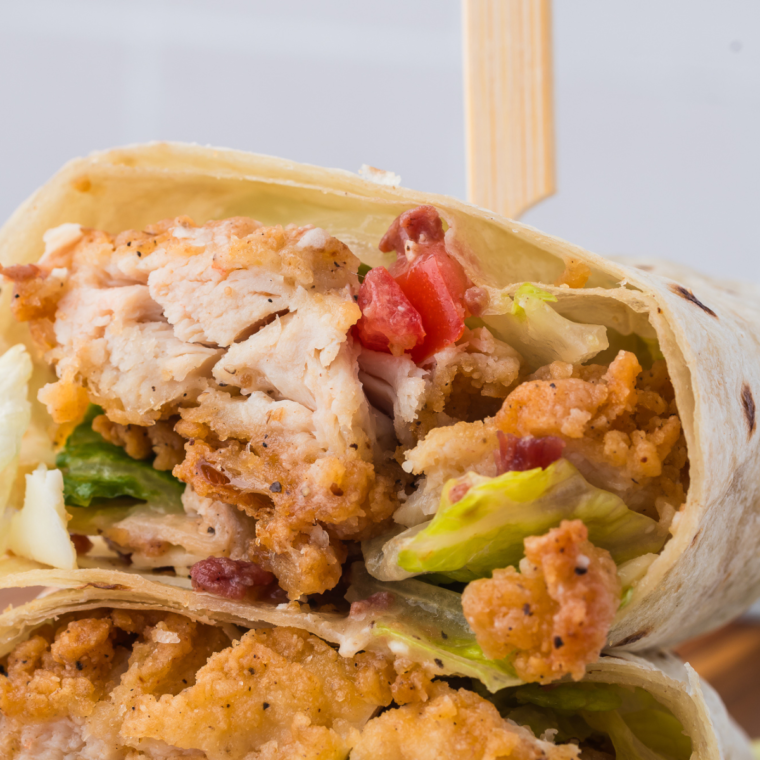 Air fryer chicken Caesar wraps cut in half showing crispy chicken, romaine, and Parmesan