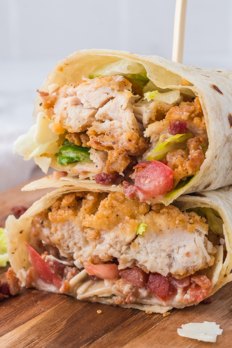 Close-up of a golden air fryer chicken Caesar wrap topped with bacon bits