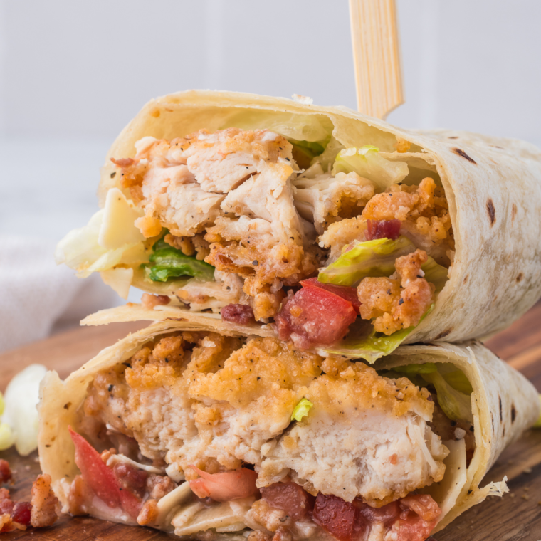 Air fryer chicken Caesar wraps with Parmesan and bacon bits served on a wooden board