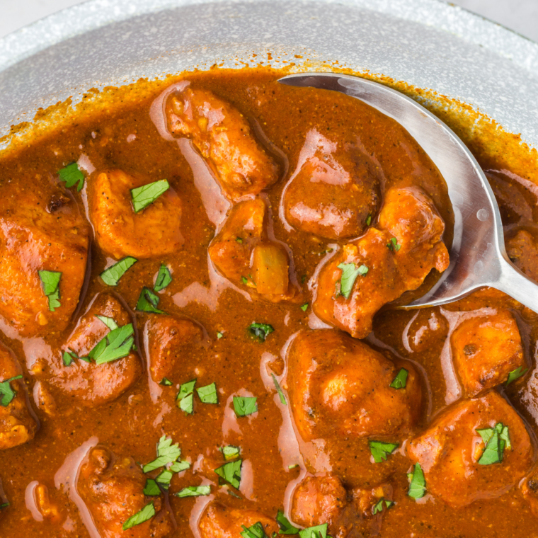 A plate of vibrant Air Fryer Chicken Vindaloo served with fluffy basmati rice and garnished with fresh cilantro.
