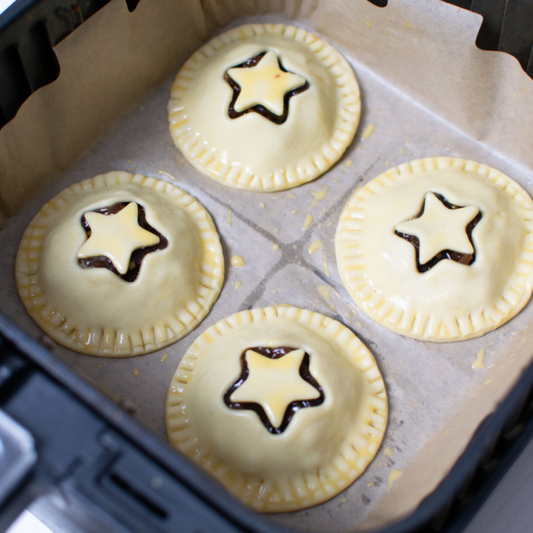 Brushing the pies with egg wash for a golden finish in the air fryer.