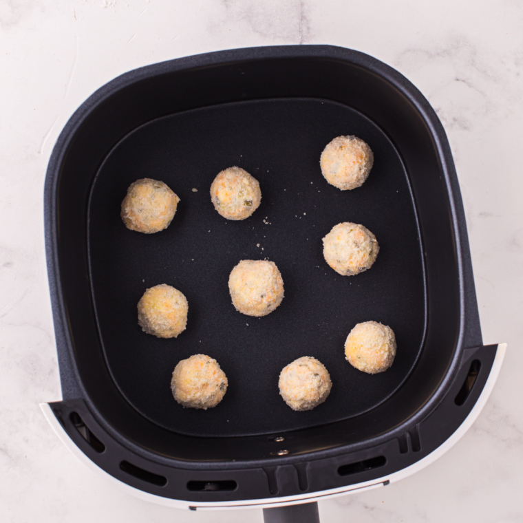 Formed pickle balls coated in breadcrumbs ready for the air fryer.